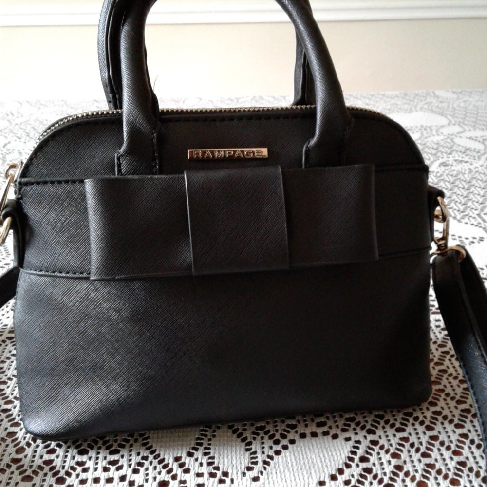 Mini Handbag with a bow in the front by Rampage. Comes with Cross Body Strap.